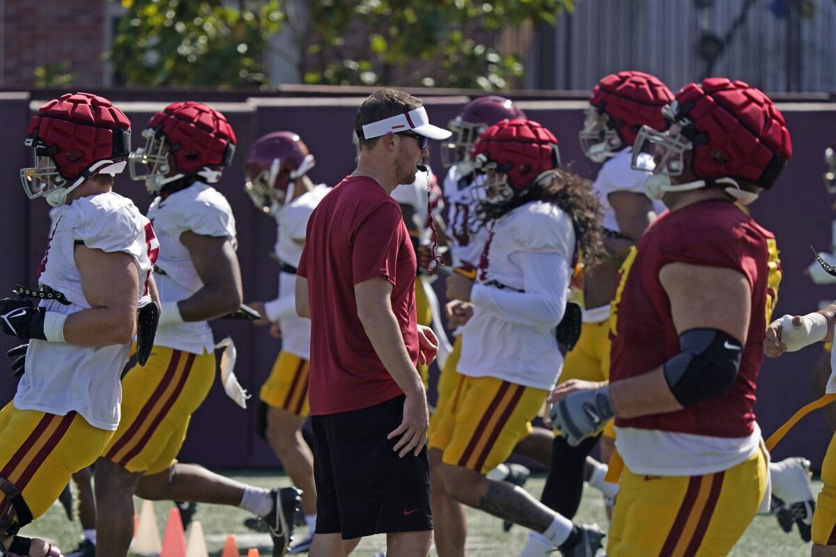 USC coach Lincoln Riley watches his team go through running drills during practice