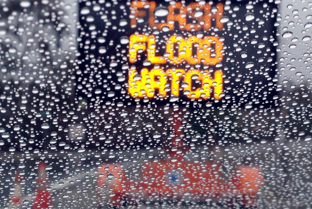A warning sign in Silverado Canyon is visible through a rain-flecked windshield.