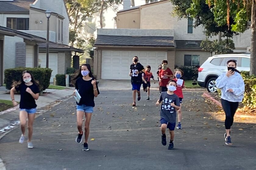 Torrey Pines and Muirlands students in a La Jolla Shores-area neighborhood run laps,.