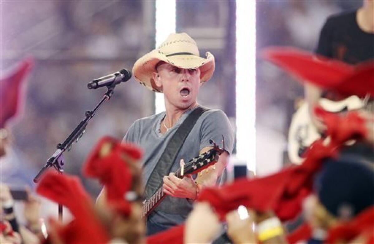 FILE - This Nov. 22, 2012 file photo shows country singer Kenny Chesney performing during halt time of an NFL football game between the Dallas Cowboys and Washington Redskins in Arlington, Texas. (AP Photo/Tim Sharp, file)