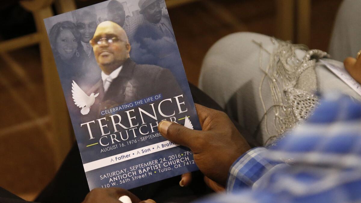 A man holds a program at the funeral of Terence Crutcher in September 2016.
