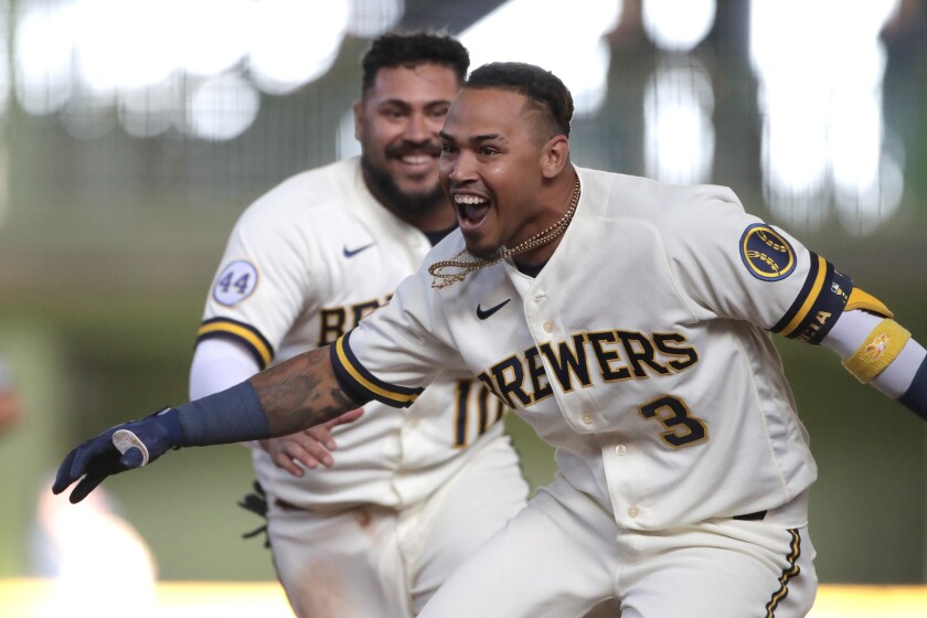 Milwaukee Brewers' Orlando Arcia celebrates with teammates after driving in the winning run during the 10th inning of the team's opening-day baseball game against the Minnesota Twins on Thursday, April 1, 2021, in Milwaukee. (AP Photo/Aaron Gash)