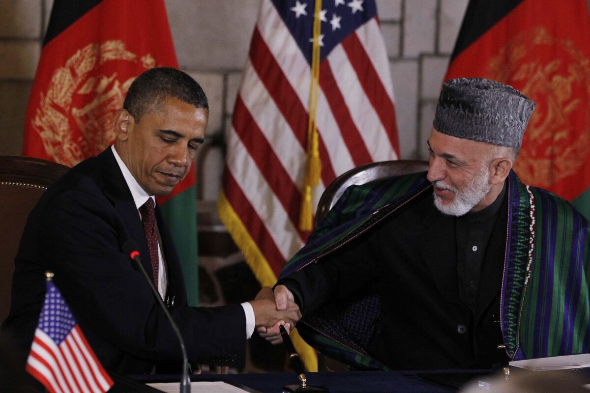 President Obama and then-President Hamid Karzai prepare to sign a strategic partnership agreement at the presidential palace in Kabul on May 2, 2012.