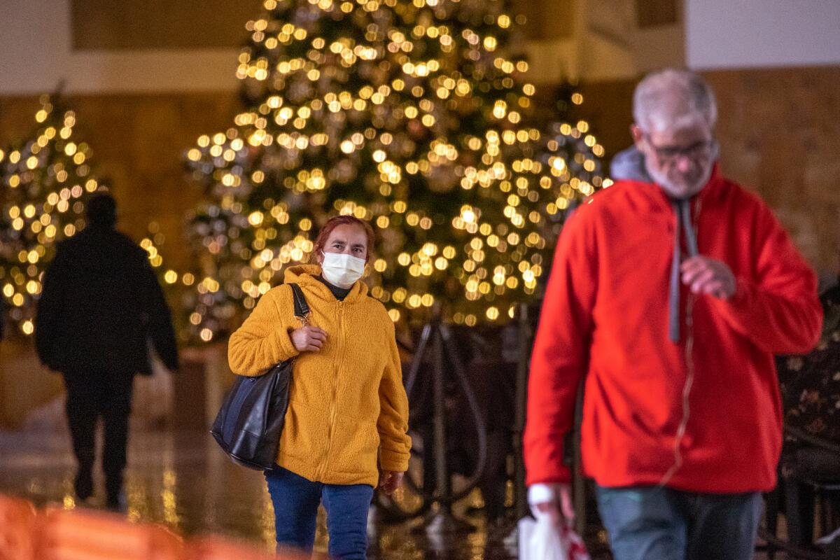 Commuters, both masked and unmasked, make their way through Los Angeles Union Station on Dec. 6. 