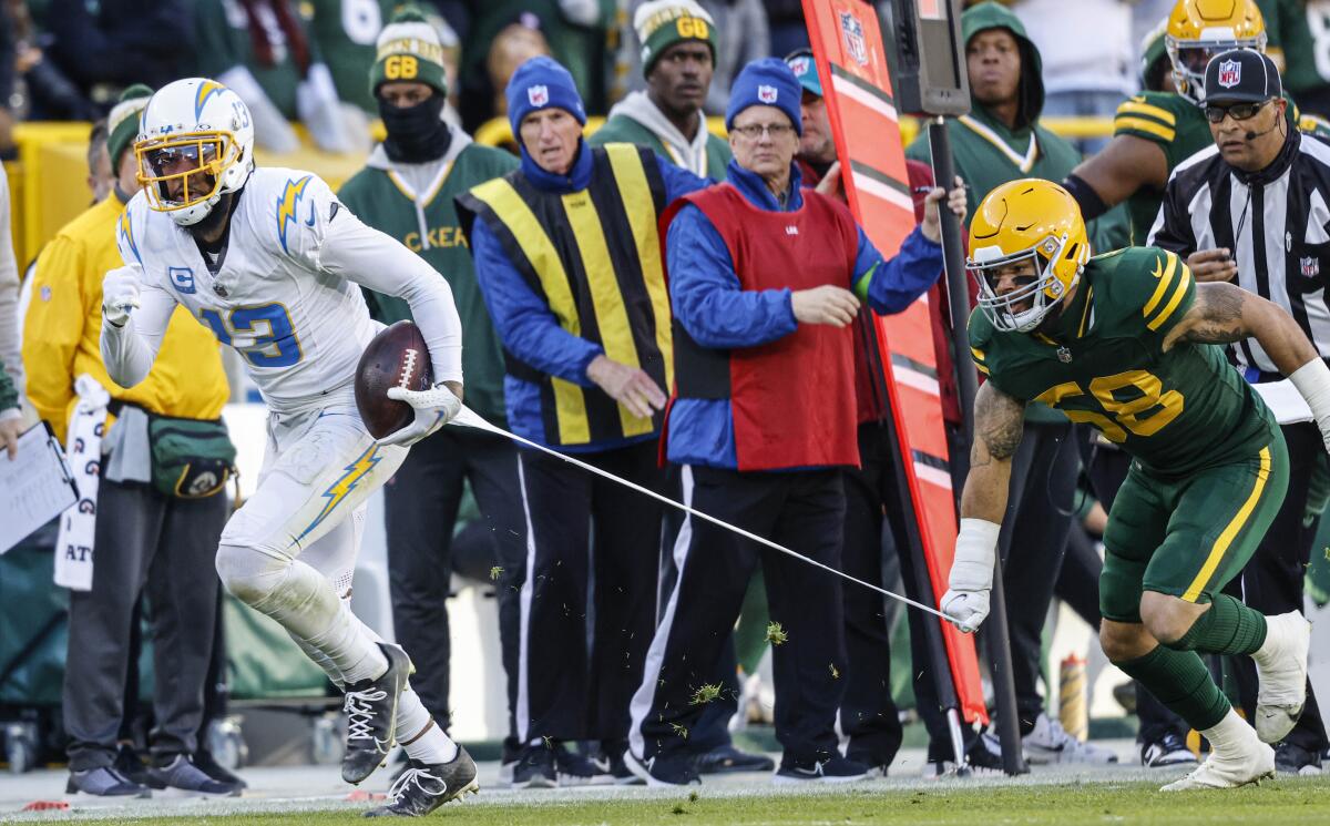 Packers linebacker Isaiah McDuffie (58) grabs some material worn by Chargers wide receiver Keenan Allen (13).