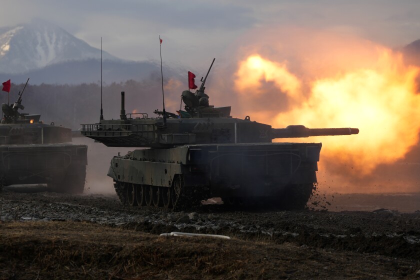 Japanese Ground-Self Defense Force (JGDDF) Type 90 tank fires its gun at a target during an annual drill exercise at the Minami Eniwa Camp Tuesday, Dec. 7, 2021, in Eniwa, Japan's northern island of Hokkaido. Dozens of tanks are rolling over the next two weeks on Hokkaido, a main military stronghold for a country with perhaps the world's most little known yet powerful army. (AP Photo/Eugene Hoshiko)
