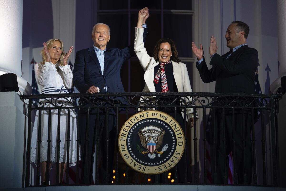 President Joe Biden raises the hand of Vice President Kamala Harris.