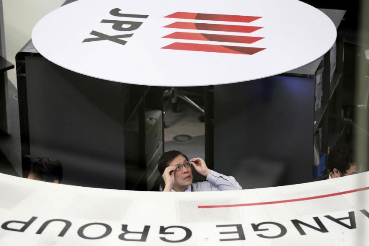 A worker at the Tokyo Stock Exchange keeps an eye on morning trading March 10.