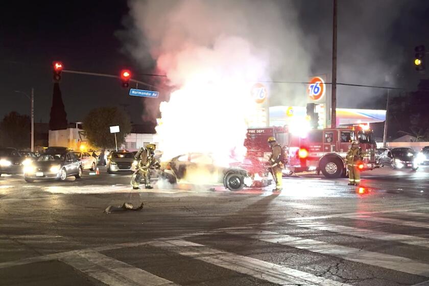 Firefighters respond to a vehicle on fire following a street takeover at the intersection of Normandie and Florence early Tuesday morning, September 3, 2024.