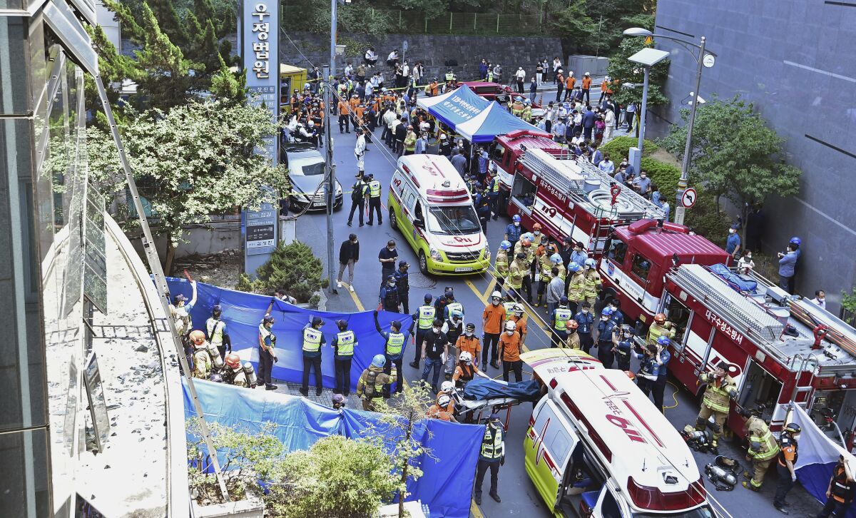 South Korean rescue teams and firefighters work at the scene in Daegu, South Korea, Thursday, June 9, 2022. At least seven people were killed and dozens of others were injured Thursday in a fire that spread through an office building in South Korea's Daegu city, local fire and police officials said. (Lee Mu-yeol/Newsis via AP)
