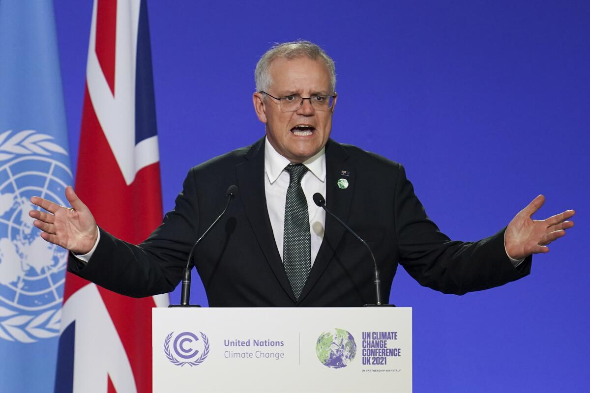 FILE - Scott Morrison, Prime Minister of Australia delivers an address, during the COP26 Summit, at the SECC in Glasgow, Scotland, Monday, Nov. 1, 2021. Morrison on Tuesday, Nov. 2, attacked the credibility of French President Emmanuel Macron as a newspaper quoted a text message that suggested France anticipated “bad news” about a now scuttled submarine deal.(Ian Forsyth/Pool Photo via AP, File)