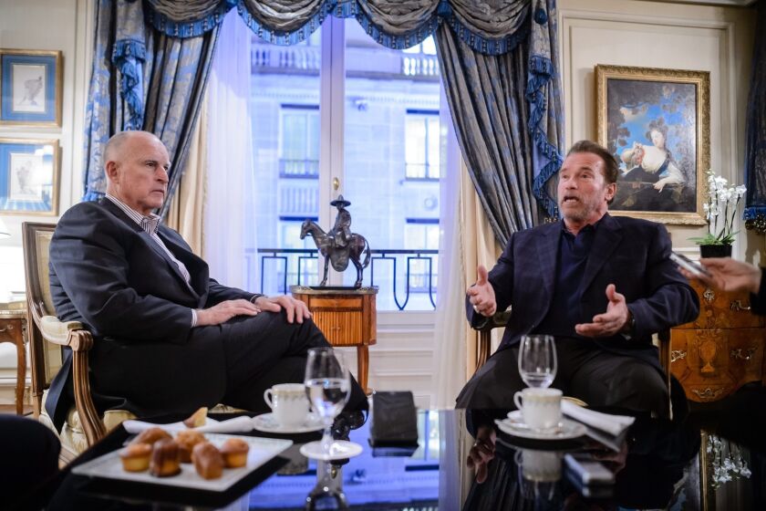 Gov. Jerry Brown and former California governor and actor Arnold Schwarzenegger during a meeting with French journalists in a Paris hotel during COP21.