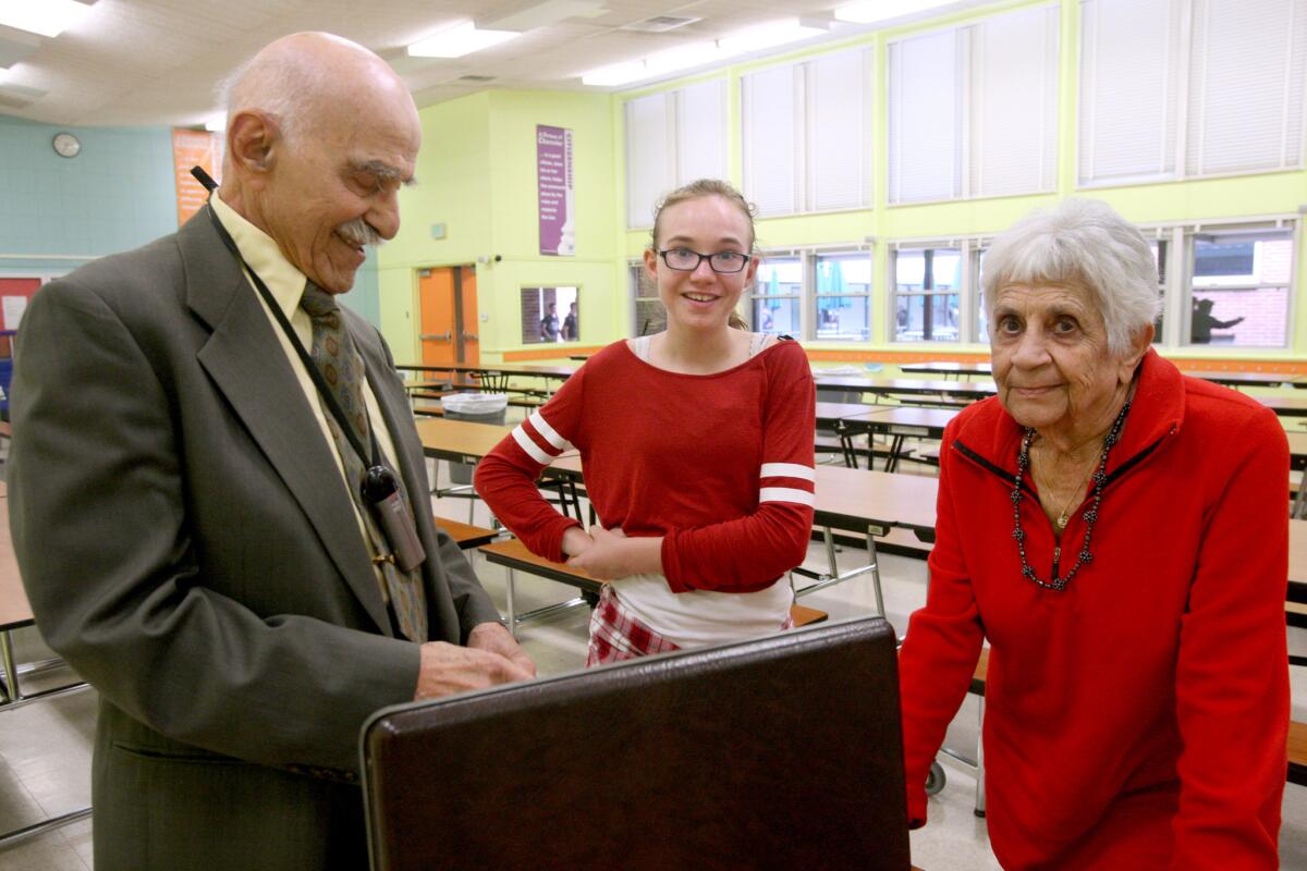 Holocaust survivor Herbert Murez, 92, left, talks with eighth-grader Mia Saunders, center, and Holocaust survivor Hilda Fogelson, 89, right, after speaking about his childhood experience, during a Holocaust Survivor talk to eighth graders at Muir Middle School in Burbank on Thursday, April 7, 2016.