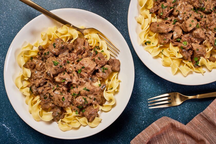 Plates of beef stroganoff with egg noodles.