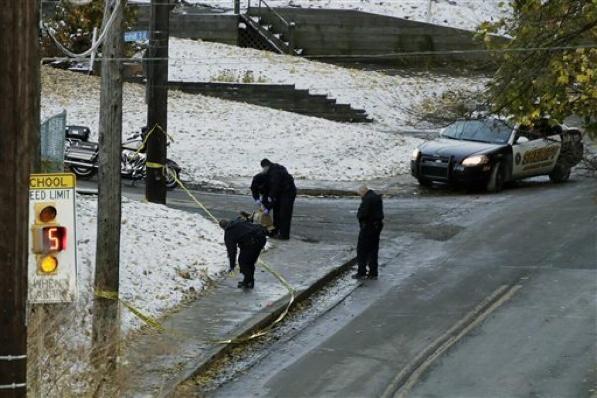 Pittsburgh police investigators go over the scene near where three high school students were shot outside a high school. The injuries did not appear to be life-threatening. Police called the incident retaliation for a beating during a drug deal.