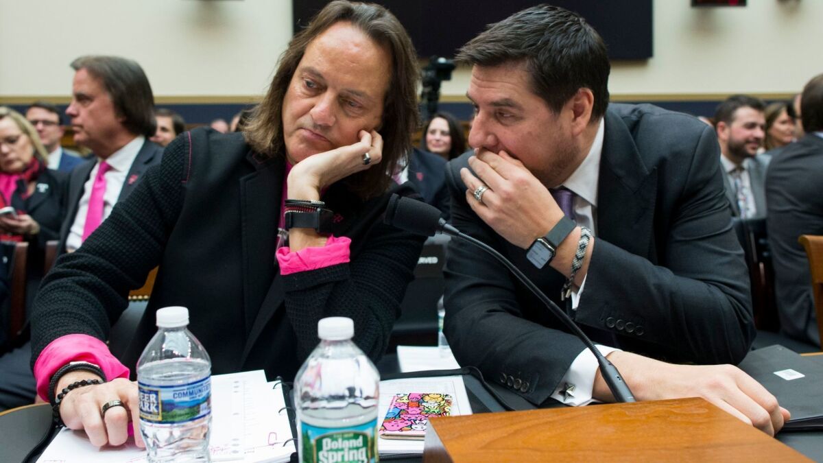 T-Mobile CEO John Legere, left, listens to Sprint Executive Chairman Marcelo Claure before testifying at a House Judiciary subcommittee hearing Tuesday.