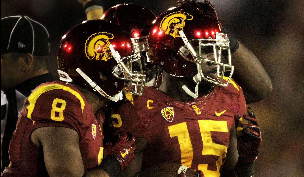 Trojans wide receiver Nelson Agholor (15) is congratulated by teammates, including fellow receiver George Farmer (8), after a 34-yard reception in the first half.