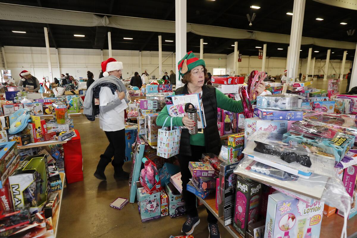 Volunteer Marilyn Smith of Irvine sorts gifts as she fulfills a wish list for Share Our Selves' 50th Adopt A Family program Wednesday at the OC Fair & Event Center in Costa Mesa.