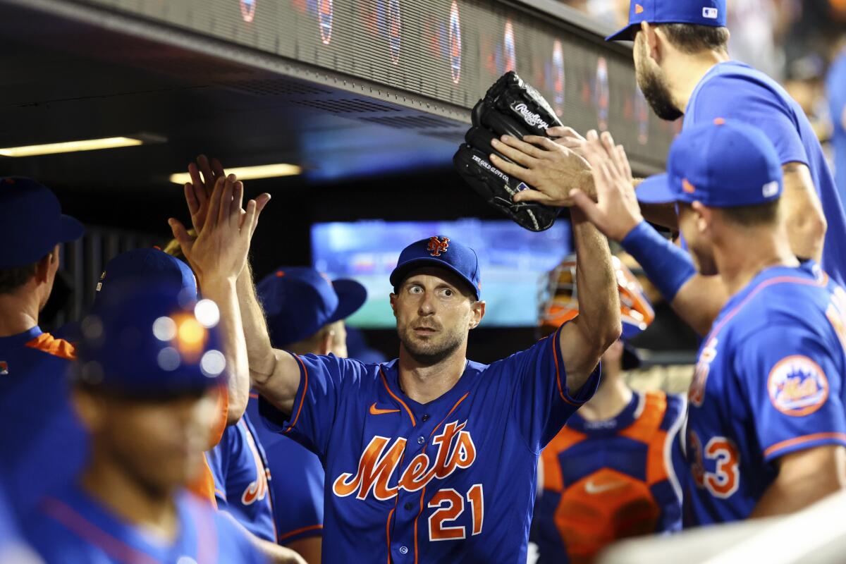 New York Mets starting pitcher Max Scherzer (21) shakes hands with teammates after the top of the seventh inning of the second game of a baseball doubleheader against the Atlanta Braves, Saturday, Aug. 6, 2022, in New York. (AP Photo/Jessie Alcheh)