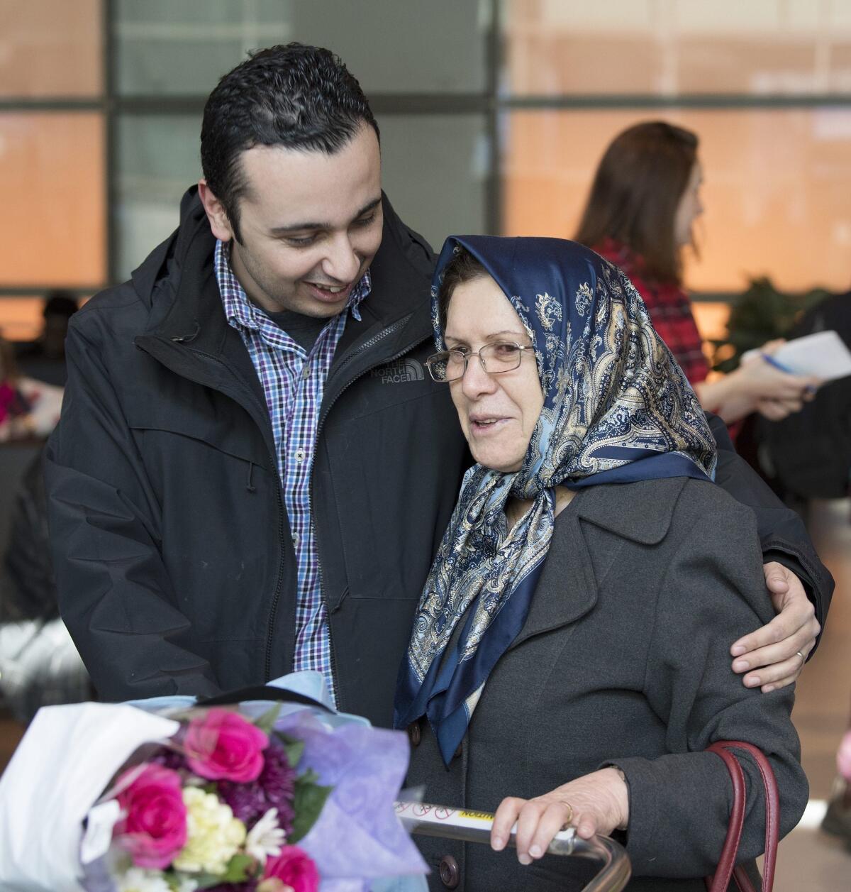 Sanam Mirzai, right, is greeted by her son as she arrives at Logan International Airport in Boston on Saturday.