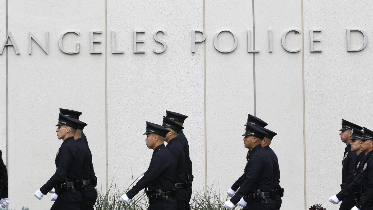 LAPD recruits walk next to the downtown police headquarters building.