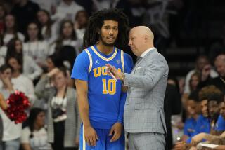 UCLA guard Tyger Campbell talks to coach Mick Cronin during a loss to Arizona