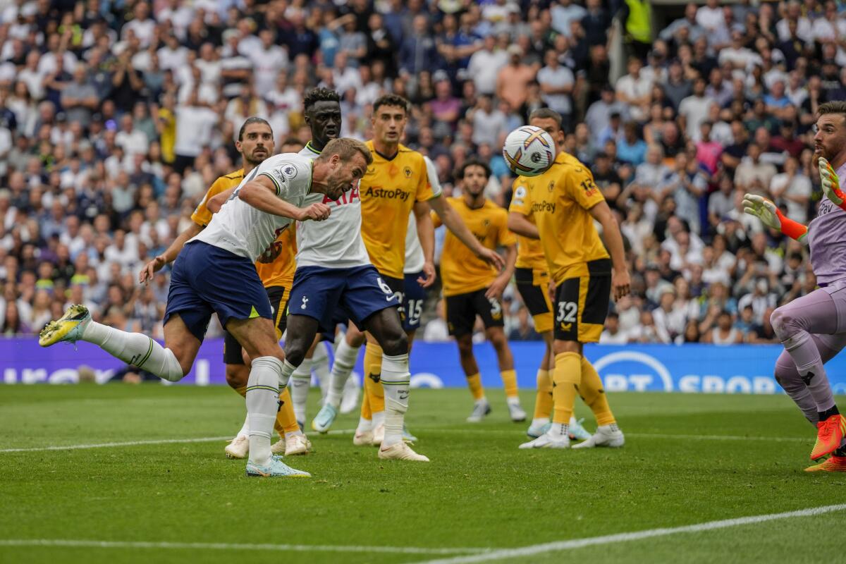 Tottenham's Harry Kane, foreground and left, scores the opening goal during the English Premier League soccer match between Tottenham Hotspur and Wolverhampton Wanderers at Tottenham Hotspur in London, Saturday, Aug. 20, 2022. (AP Photo/Frank Augstein)