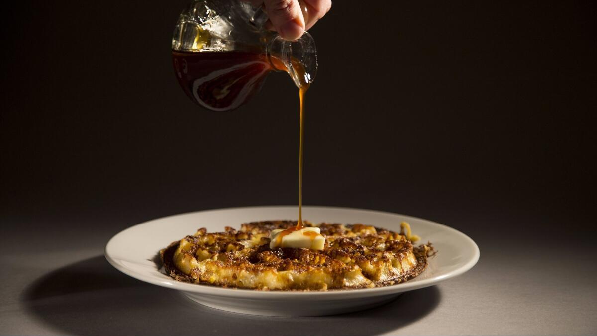 Apple cider syrup is poured onto a cornmeal waffle, based on a recipe out of the cookbook from the restaurant Brown Sugar Kitchen in West Oakland.