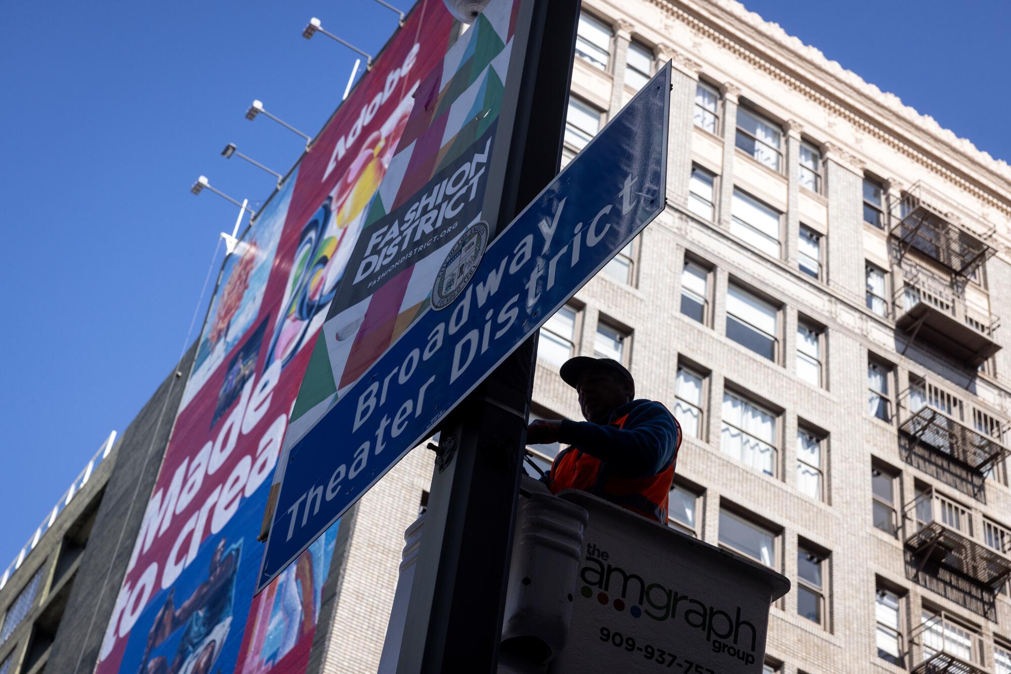 A worker removes a banner on Broadway.