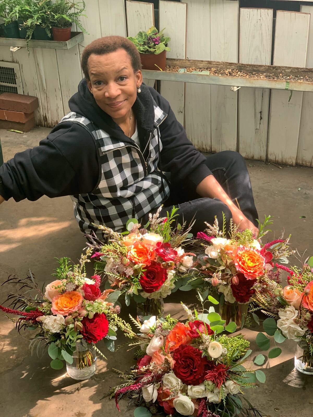 In this Oct. 12, 2019, photo provided by Angie Morton, Lisa Taylor poses with a flower arrangement taken at Rachel’s Flowers in Memphis, Tenn. An emergency management official in Shelby County, Tenn., said Taylor was found dead Saturday, Dec. 11, 2021, after a tree uprooted in a violent storm fell through the roof of her Memphis home, landing on Taylor as she slept. Co-workers said she recently left her job as a florist of 14 years for a government job at the Memphis airport. (Angie Morton via AP)