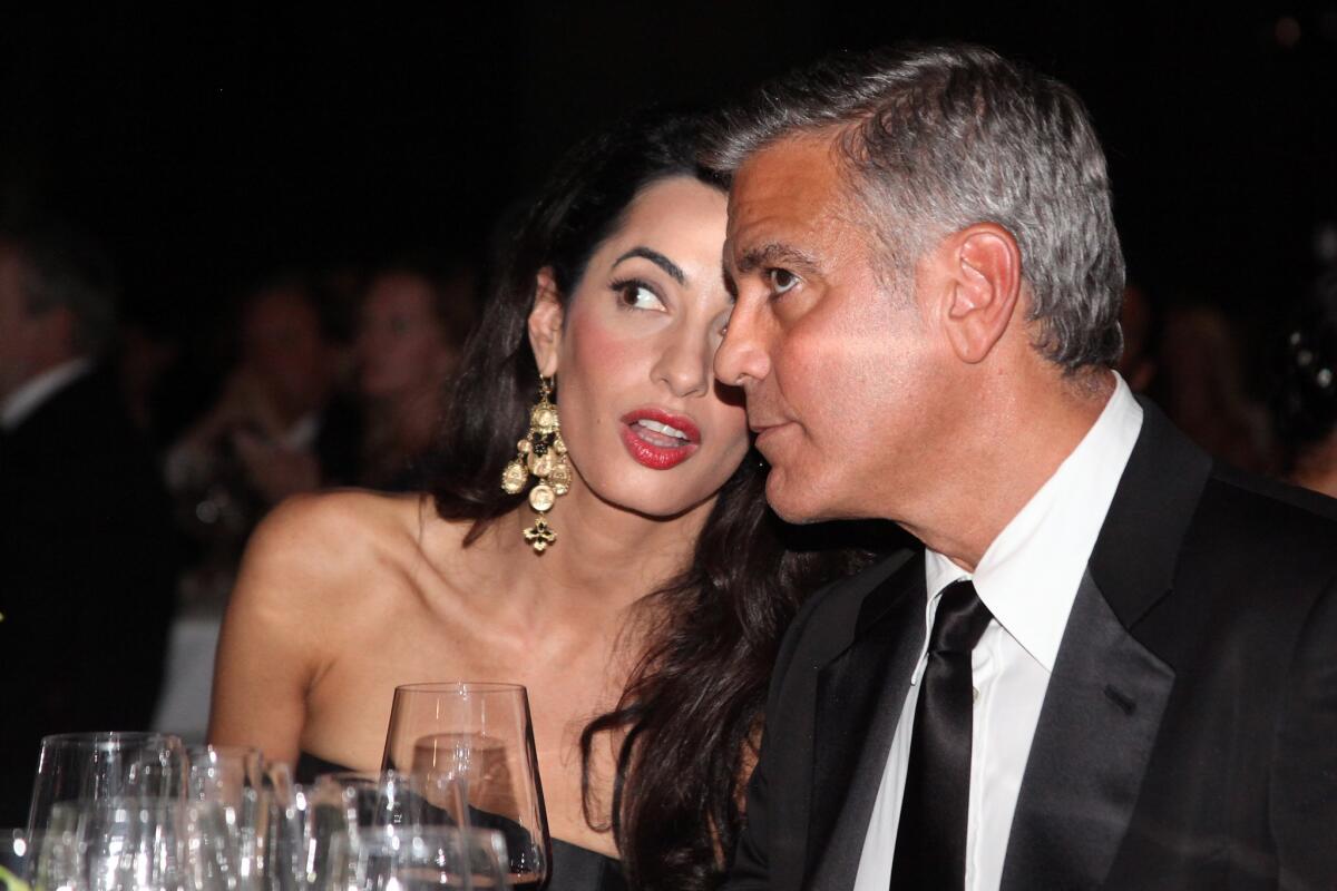 Amal Alamuddin and George Clooney at the charity event in Florence, Italy, where he spilled the beans about their wedding going down in Venice.