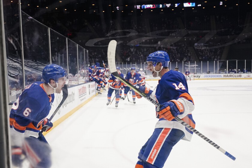 New York Islanders' Ryan Pulock (6) celebrates with teammate Travis Zajac (14) after scoring the winning goal during the overtime period of an NHL hockey game against the New York Rangers, Sunday, April 11, 2021, in Uniondale, N.Y. (AP Photo/Frank Franklin II)