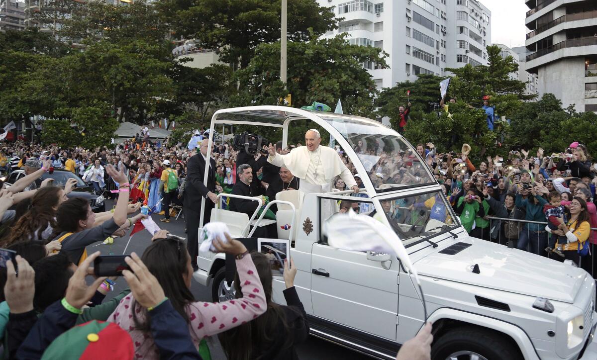 Pope Francis waves to a crowd from the pope mobile.
