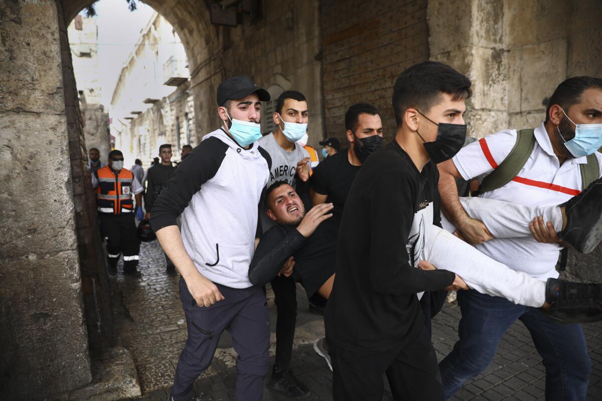 Palestinians evacuate a wounded protester during clashes with Israeli security forces at Lions Gate in Jerusalem's Old City.