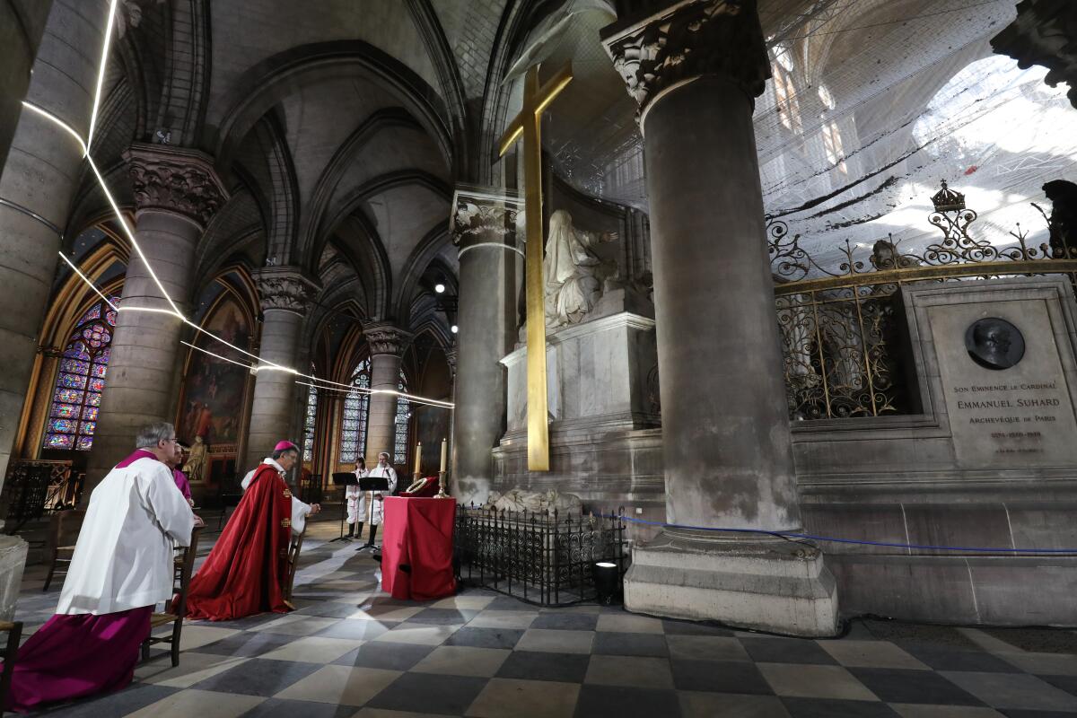 Priests hold Good Friday services in a still-scarred and empty Notre Dame Cathedral in Paris almost a year after a devastating fire heavily damaged the historic structure.