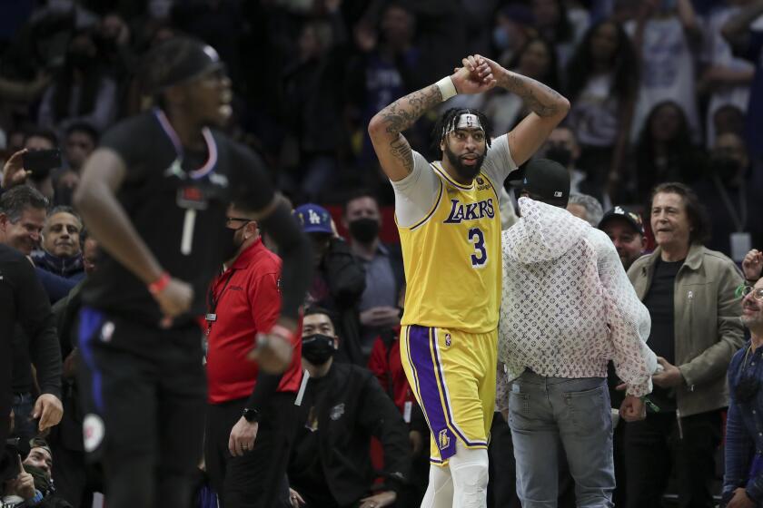 Los Angeles, CA - February 03: Los Angeles Lakers forward Anthony Davis (3) looks on in dejection as LA Clippers guard Reggie Jackson (1) celebrates the Clippers win at Crypto.com Arena on Thursday, Feb. 3, 2022 in Los Angeles, CA. (Allen J. Schaben / Los Angeles Times)