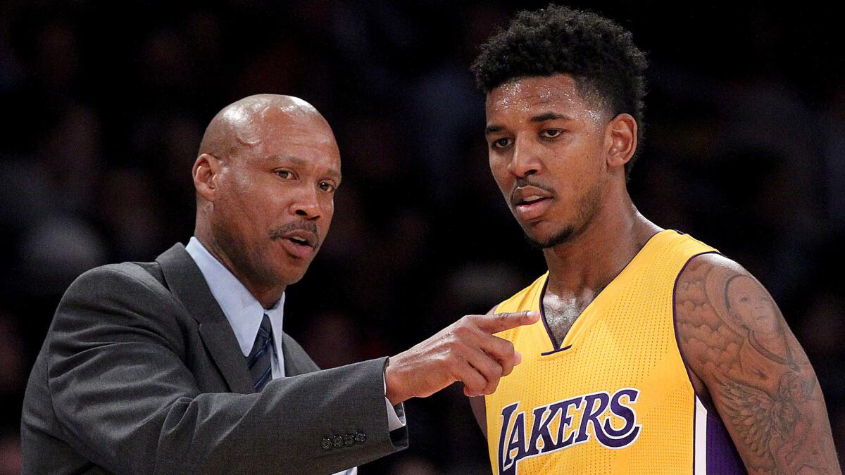 Lakers Coach Byron Scott, left, speaks with small forward Nick Young during a game against the Sacramento Kings at Staples Center.