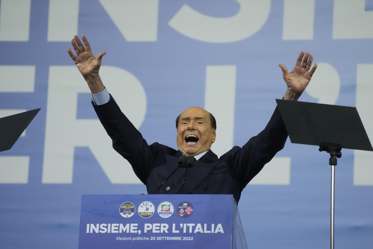 Former Italian Prime Minister Silvio Berlusconi raising his arms in the air