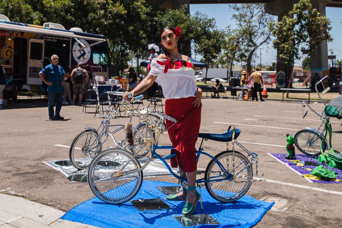 Julia Orozco poses on a lowrider bicycle during an Open House event in Chicano Park Saturday.