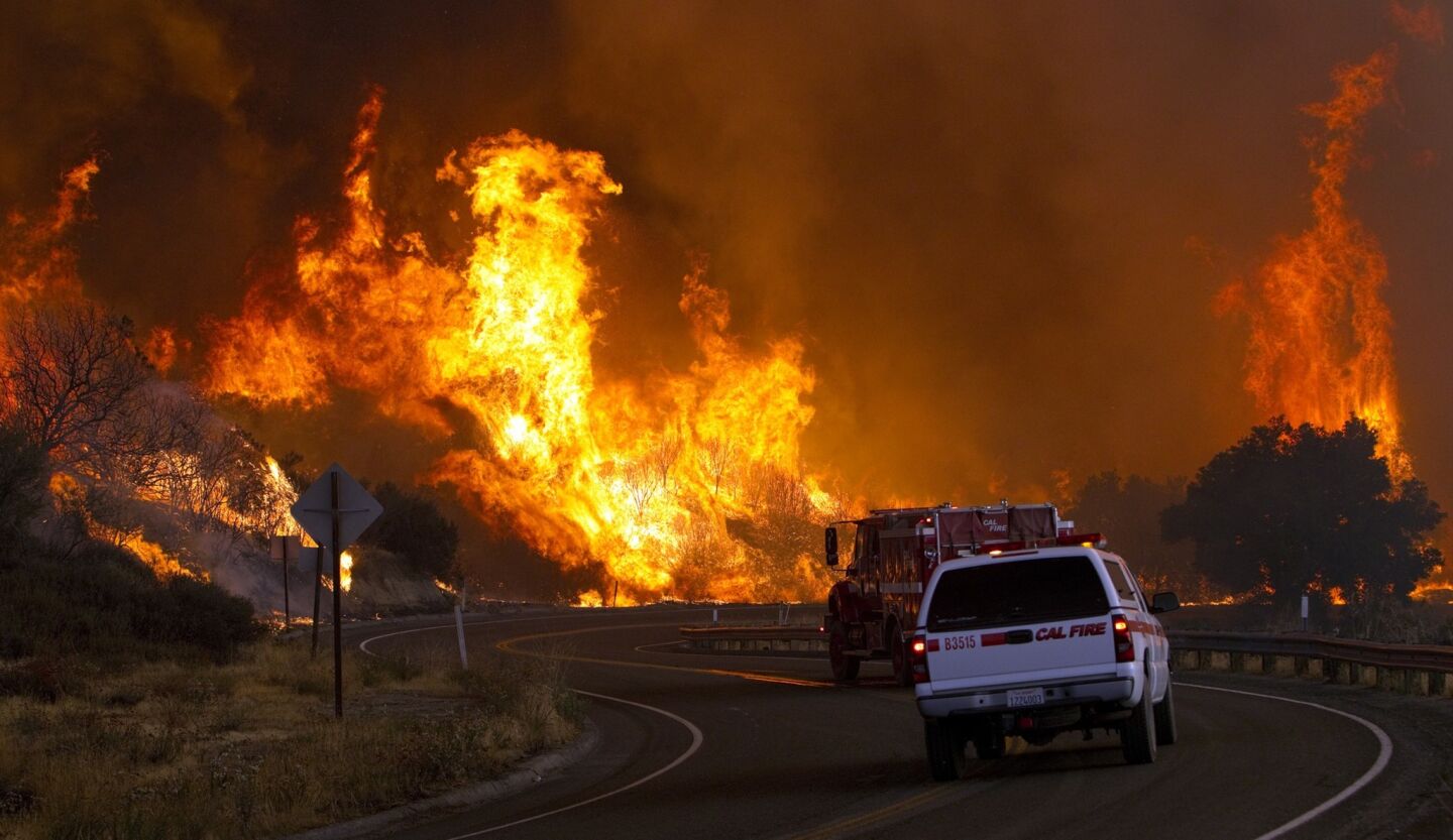 Firefighters with the California Department of Forestry and Fire Protection drive toward a dangerous wall of flame while battling the fire.