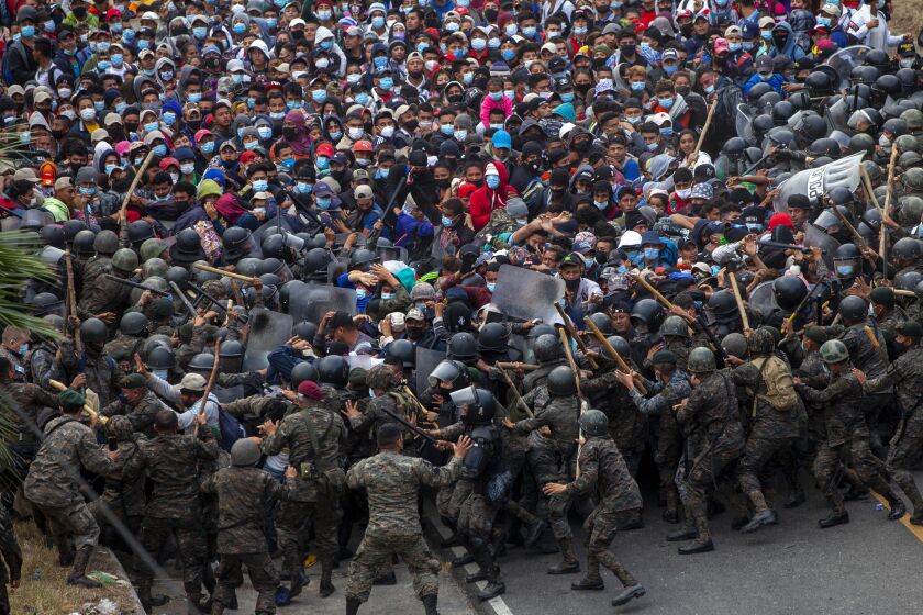 Honduran migrants clash with Guatemalan soldiers in Vado Hondo, Guatemala, Sunday, Jan. 17, 2021. Guatemalan authorities estimated that as many as 9,000 Honduran migrants crossed into Guatemala as part of an effort to form a new caravan to reach the U.S. border. (AP Photo/Sandra Sebastian)