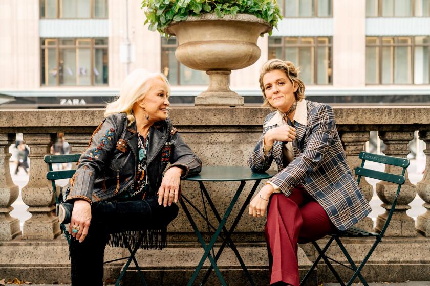 New York, NY - October 19, 2022: Tanya Tucker, left, and Brandi Carlile sitting at a table outside of the New York City Public Library in Manhattan. (Clark Hodgin / For the Times)