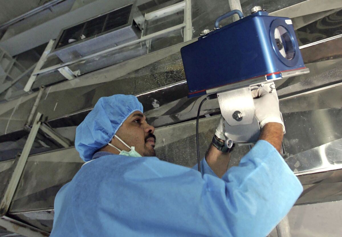 FILE - An inspector of the International Atomic Energy Agency sets up surveillance equipment, at the Uranium Conversion Facility of Iran, just outside the city of Isfahan, Iran, Aug. 8, 2005. Iran turned off two surveillance cameras of the United Nations' nuclear watchdog that monitored one of its atomic sites, state television reported Wednesday, June 8, 2022. The report did not identify the site. (AP Photo/Mehdi Ghasemi, ISNA, File )