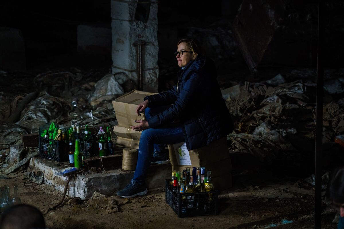 A woman rests near bottles used to make Molotov cocktails.