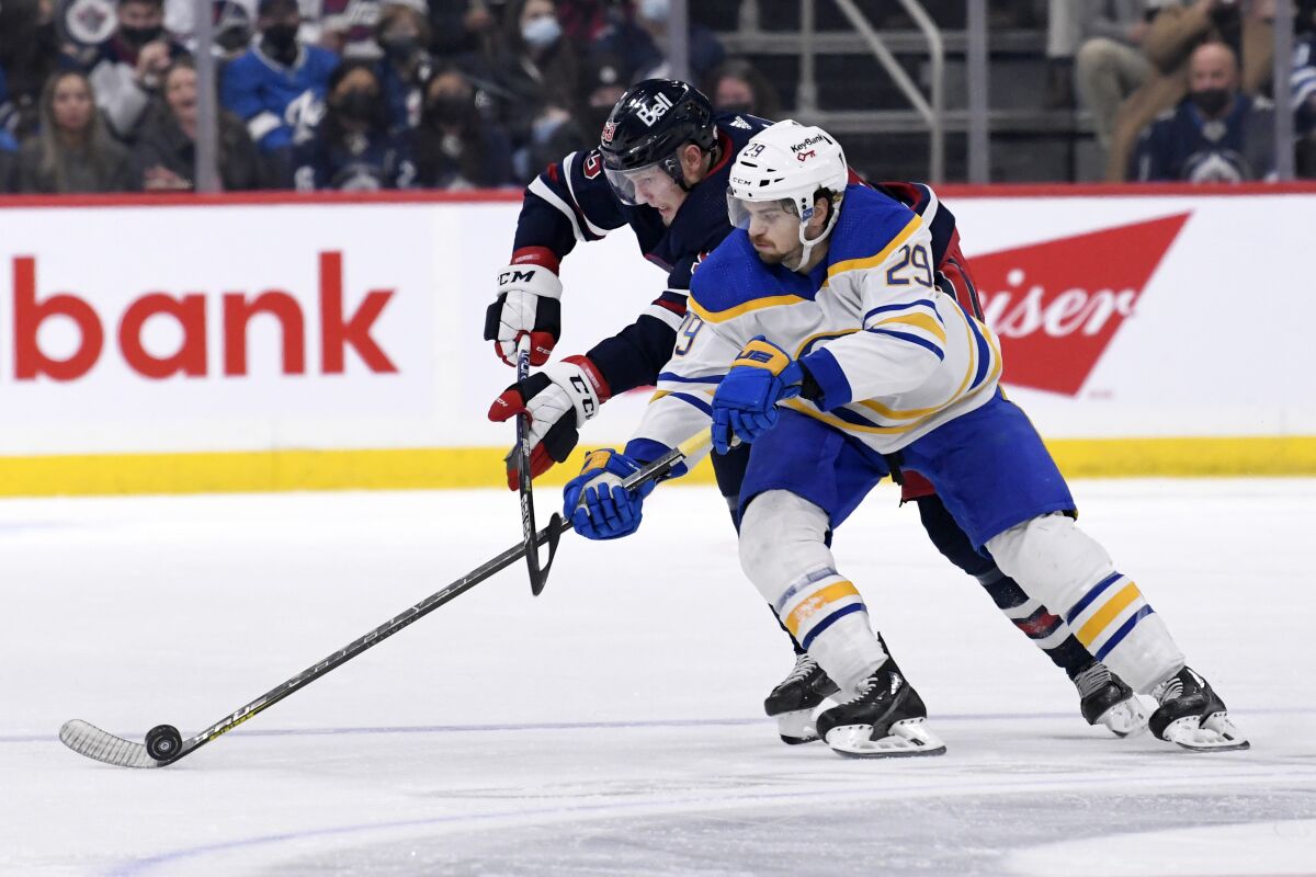 Winnipeg Jets' Kristian Vesalainen (93) chases after Buffalo Sabres' Vinnie Hinostroza (29) during the second period of an NHL hockey game in Winnipeg, Manitoba, Tuesday, Dec. 14, 2021. (Fred Greenslade/The Canadian Press via AP)