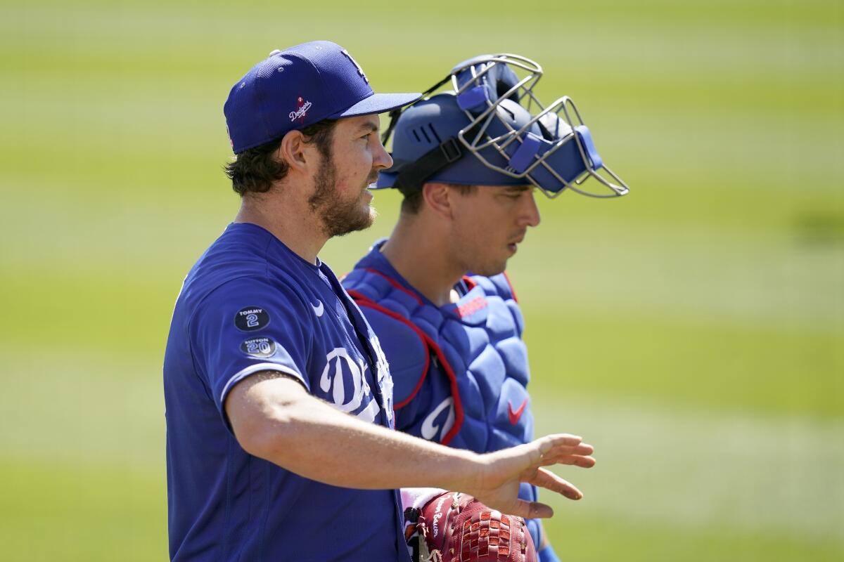 Dodgers pitcher Trevor Bauer talks with catcher Austin Barnes after warming up in the bullpen March 6, 2021, in Phoenix.