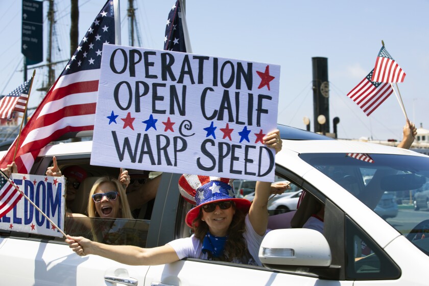A large group held a rally on Saturday in front of the San Diego County Administration building and listened to various speakers. Others stayed in heir cars and drove by waving posters and blasting their car horns. The group was demanding for elected leaders to open California.