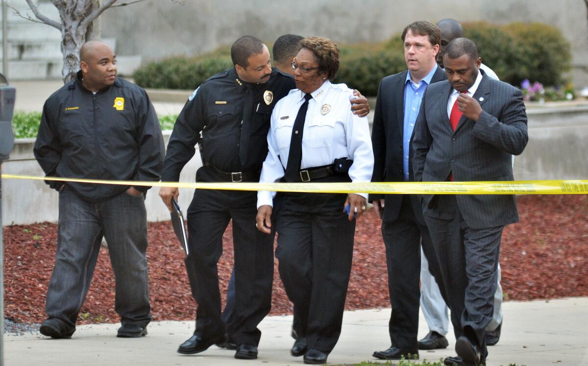 Jackson, Miss., Assistant Police Chief Lee Vance, center left, comforts Chief Rebecca Coleman, center right, after the slaying of a detective.