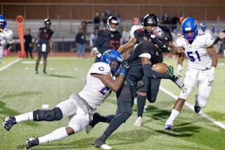 Dymally runner Bryant Collins gains a first down before being dragged down by Crenshaw’s Jeremiah Blackmon.