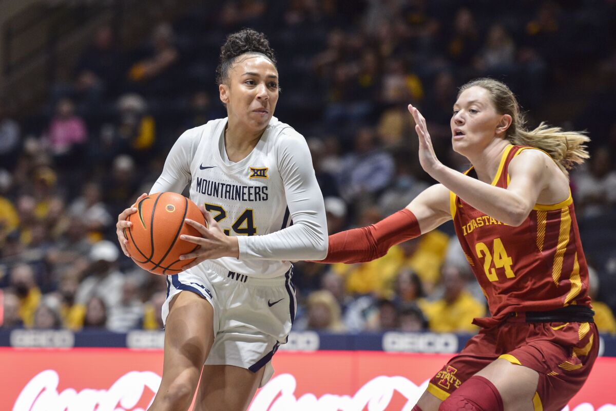 West Virginia guard Savannah Samuel (24) protects the ball from Iowa State guard Ashley Joens (24) during the first half of an NCAA college basketball game in Morgantown, W.Va., Saturday, March 5, 2022. (AP Photo/William Wotring)